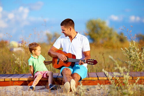 father-playing-guitar-to-child